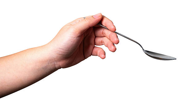 istock Female hand holding a black plastic spoon isolated on white background. 2223866178