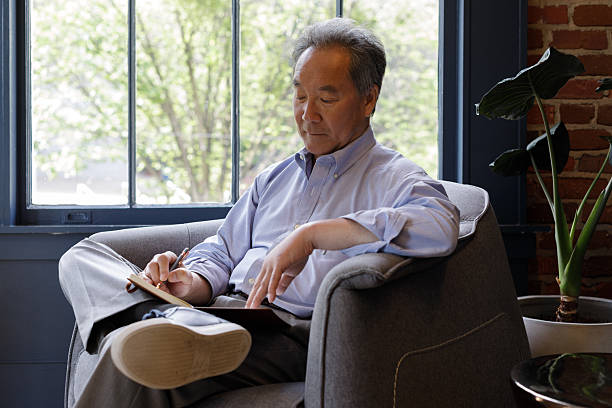 istock friendly Asia elderly man sits and takes notes during meeting 2223871816