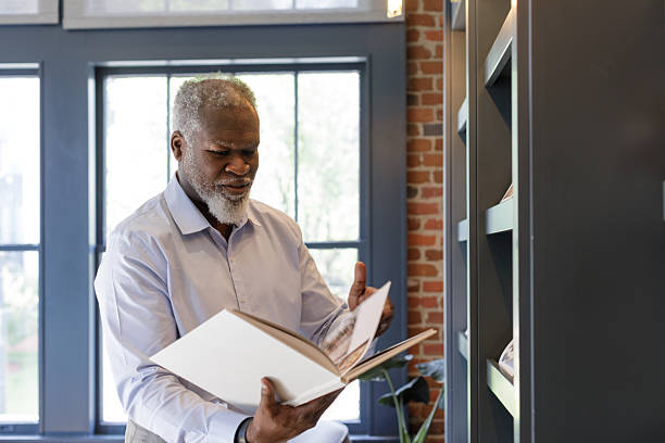 istock African american man selects and browses through book 2223871831