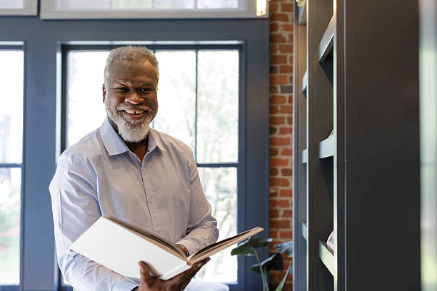 istock African american man holding book, smiles, looking at camera 2223871832