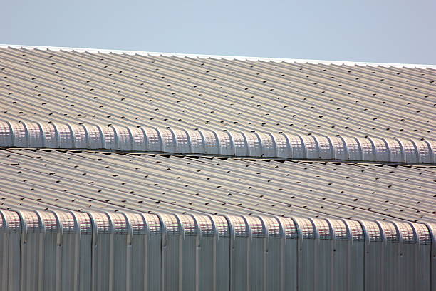 architecture design curve shape corrugated wall geometric building. The factory warehouse is exterior decorated with corrugated texture to create a point of interest against blue sky, close up