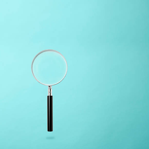 istock Magnifying glass floating in mid-air against light blue background 2223876567