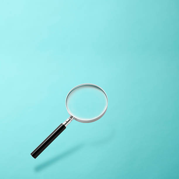 istock Magnifying glass floating in mid-air against light blue background 2223876571