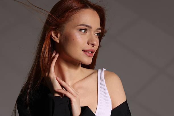 Beautiful young woman posing on gray background