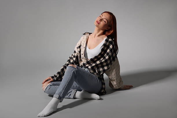 istock Beautiful young woman sitting on gray background 2223877270