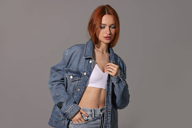 istock Beautiful young woman in denim jacket on gray background 2223877302