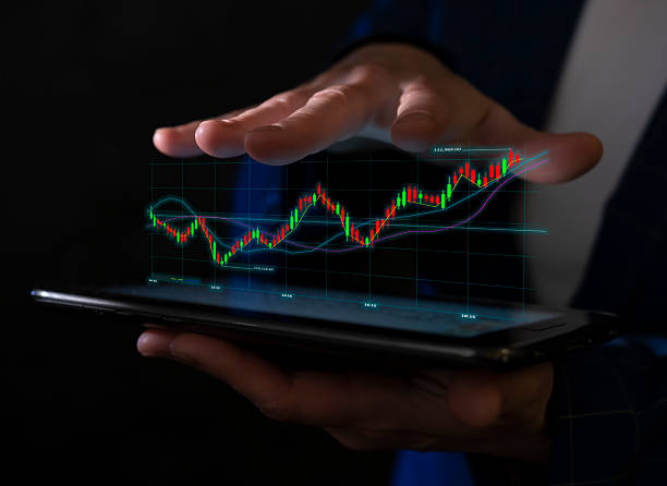 istock Hands display stock market data on a digital tablet with colorful graph trends in a dark environment 2223877478