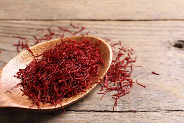 istock Aromatic saffron and spoon on wooden table, closeup 2223877568