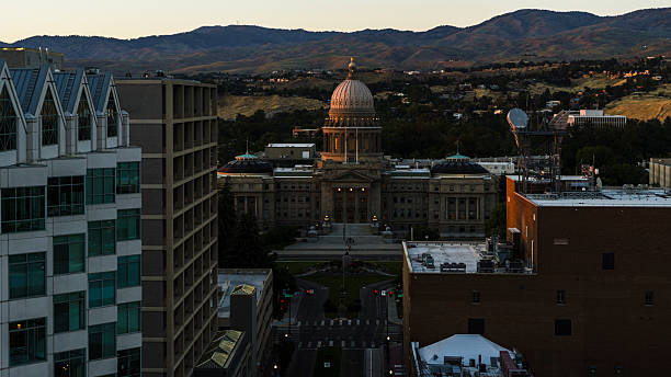 istock Cityscape featuring illuminated Idaho State Capitol visible from downtown. Modern buildings frame government center with mountain range in Boise, Idaho. 2223877645
