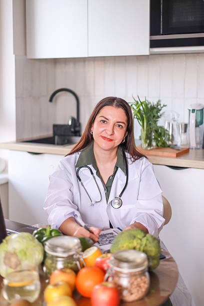 istock nutritionist in a white coat working at a table with fresh products and modern gadgets. nutrition concept, wellness programs. 2223879395