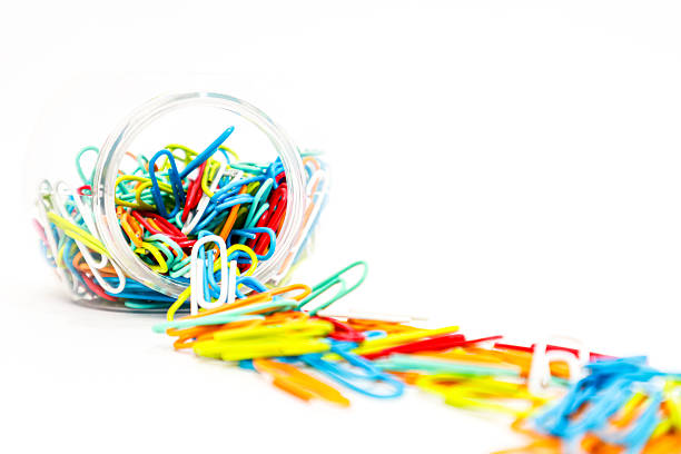 istock Vibrant Paper Clips Spill from Glass Jar on White Surface Creating Colorful Chaos 2223881957