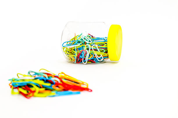 istock Colorful paper clips in a jar and scattered on a white background, isolated 2223882436