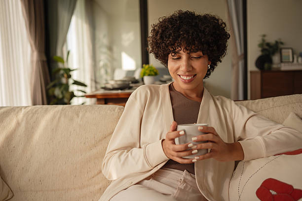 istock Woman relaxing on sofa with a cup of coffee 2223883083