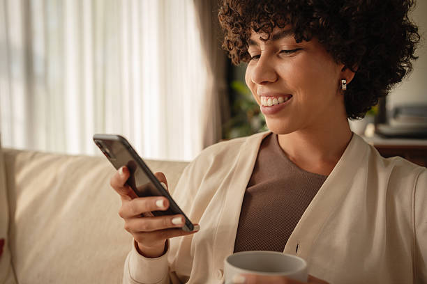 istock Woman relaxing on a sofa with a phone and coffee 2223883084