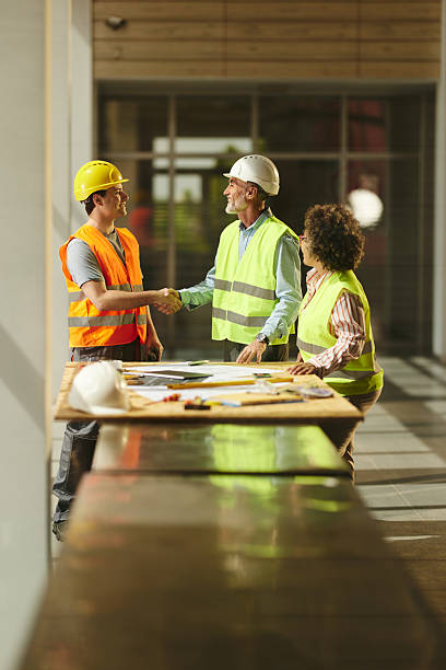 istock Happy project manager greeting a construction worker in the building. 2223885027
