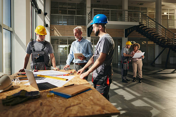 istock Inspector and manual workers reading blueprints in construction building. 2223885072
