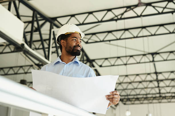 istock Below view of happy black architect working on blueprints. 2223885151