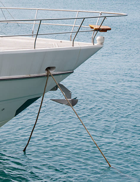 A boat is tied to the dock with a rope. The water is calm and the boat is large