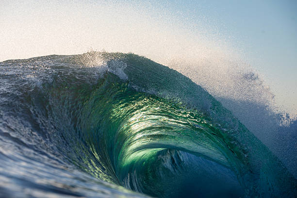 istock A beautifully vibrant backlit emerald gold coloured glassy surfing wave breaking over a shallow reef. 2223891594