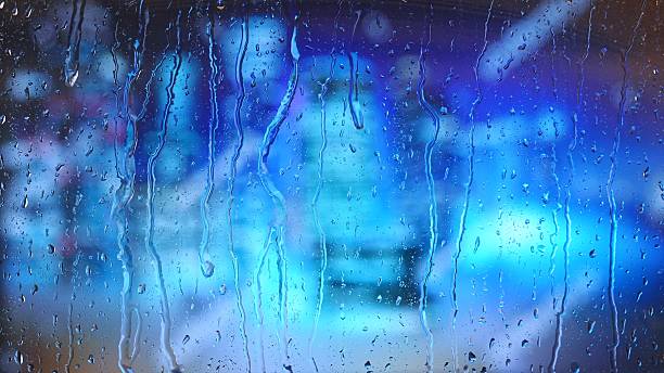 istock Rain drops on glass with colorful blurred blue city lights 2223891685
