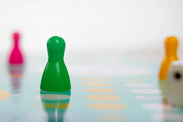 Bright green game piece placed on a pastel-colored board, illustrating board game elements and entertainment in macro playful perspective.