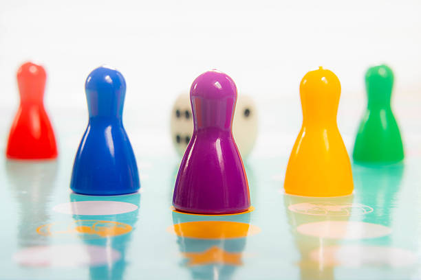 istock Colorful plastic pawns in a row on game board depicting teamwork and playful competition 2223891881