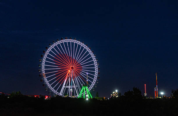 Antalya, Turkiye -  April 27, 2025: A vibrant ferris wheel illuminated with colorful lights during the blue hour in a Luna Park in Antalya, Turkey.