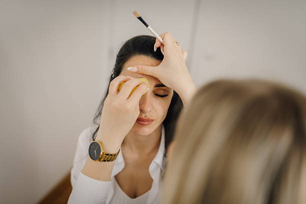 istock Makeup artist applying foundation on model's face with sponge 2223895455