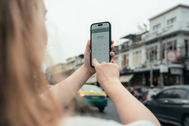 gros plan d’une touriste qui entre un code d’accès numérique sécurisé dans une application intelligente sur son téléphone intelligent pour accéder à distance à sa chambre d’hôtel - facilité daccès photos et images de collection