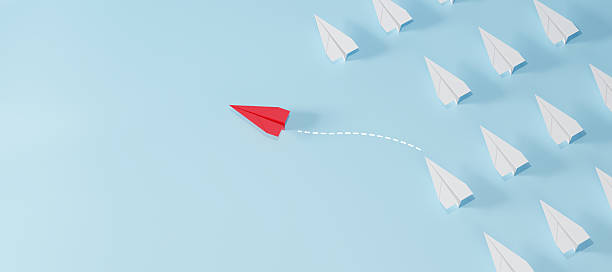 istock Red paper plane flying in different direction from white planes on blue background. Concept of leadership, innovation, thinking differently, and standing out. 2223896830