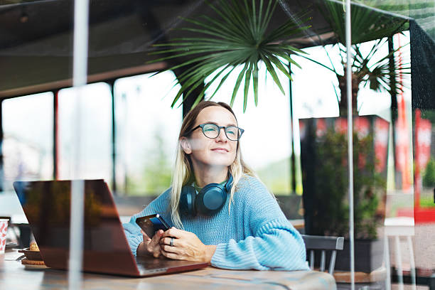 Mid adult woman working using laptop from cafe