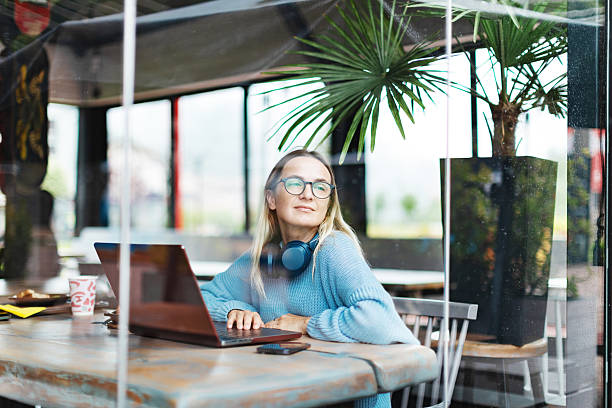 istock Mid adult woman working using laptop from cafe 2223900180