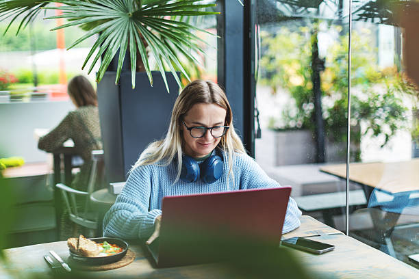 istock Mid adult woman working using laptop from cafe 2223900304