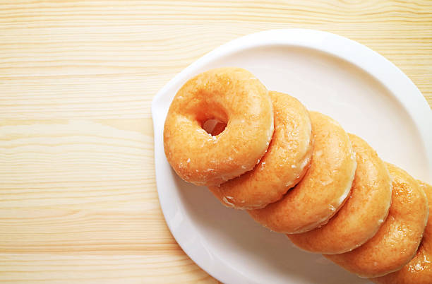 istock Plate of Delectable Sugar Glazed Doughnuts on Wooden Background 2223901018