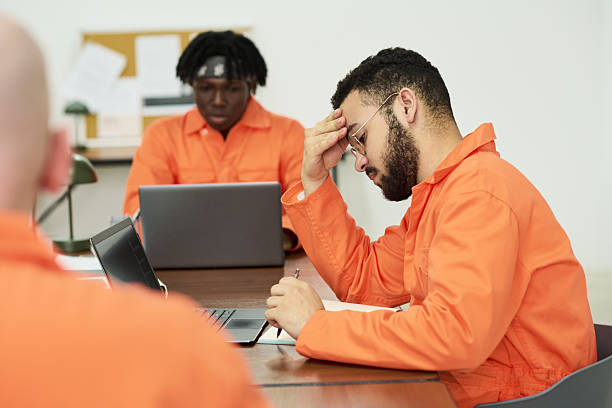 istock Young Man Studying with Laptop among Incarcerated Students in Classroom 2223901330