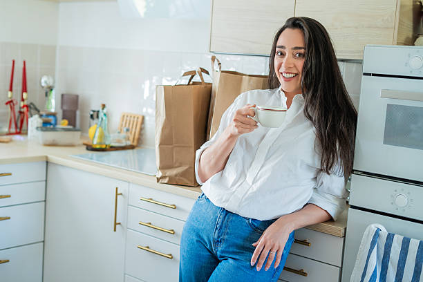 istock Young woman drinking hot coffee at home in the kitchen. 2223902068