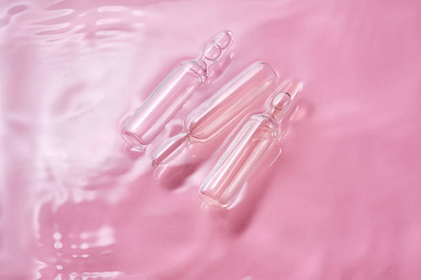 istock Ampoules in water on a pink background. 2223902897