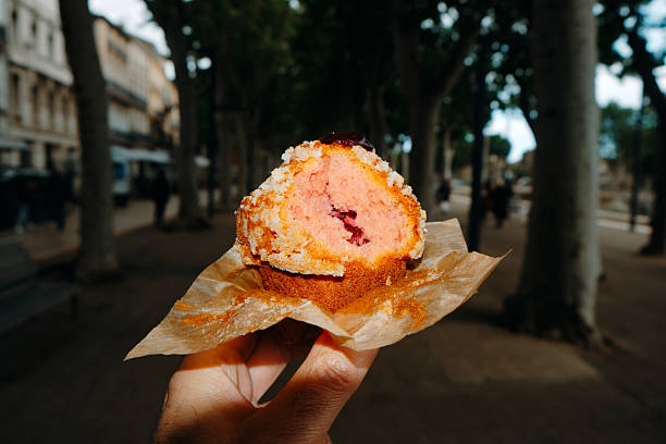 istock man eating a muffin filled with strawberry jam 2223903411