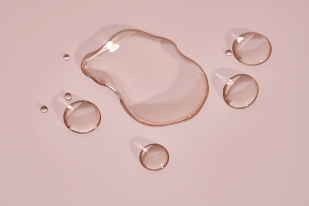istock The texture of micellar water on a pink background. 2223905195