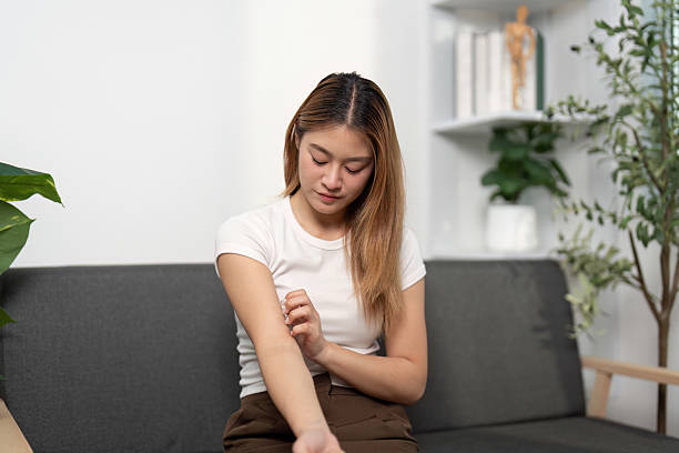 istock Health Awareness: Young woman examining her arm for discomfort. 2223906490