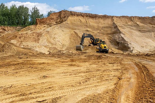 istock A caterpillar tractor works with a bucket in a sand pit. Sand mining 2223906658
