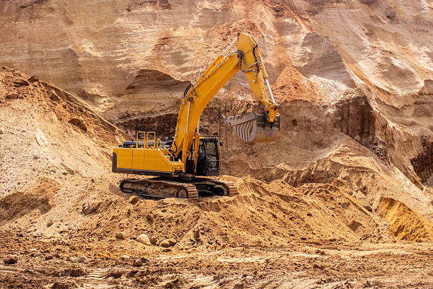 istock A caterpillar tractor works with a bucket in a sand pit. Sand mining 2223907020