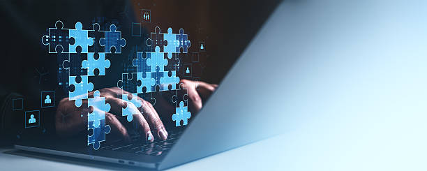 istock Hands typing on laptop with digital puzzle pieces representing teamwork and global collaboration for business success on gradient blue background. 2223907637