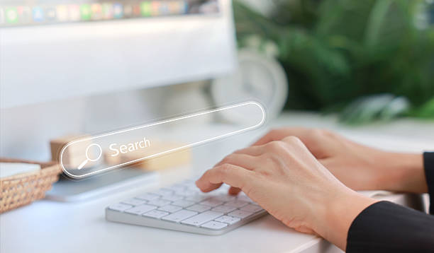 istock Hands typing on a white keyboard with search bar overlay, representing internet browsing, SEO, online research, digital marketing, communication, data input, coding and information search concept. 2223907771