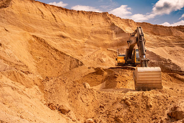 istock A caterpillar tractor works with a bucket in a sand pit. Sand mining 2223907944