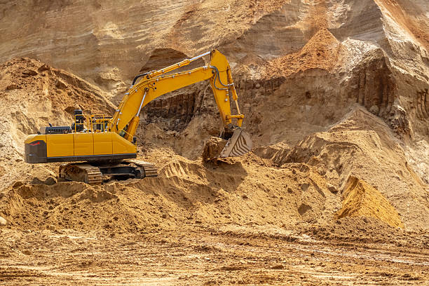 istock A caterpillar tractor works with a bucket in a sand pit. Sand mining 2223908210