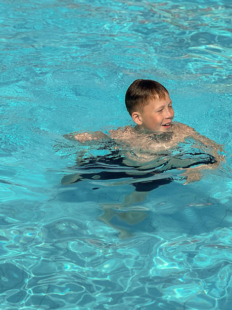 istock 10 year old boy swimming in the pool 2223908662
