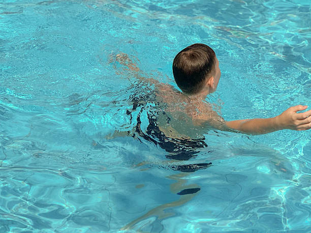 istock 10 year old boy swimming in the pool 2223908667