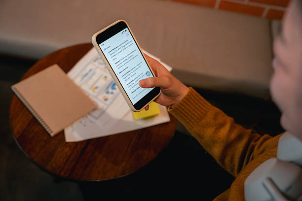 Close-up of a college student focused on her smartphone, using a modern AI app to help with her studies
