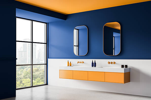 istock Modern bathroom interior design with bold blue walls, orange ceiling, and minimalist vanity and mirrors in bright daylight city view setting. 3D Rendering 2223908709